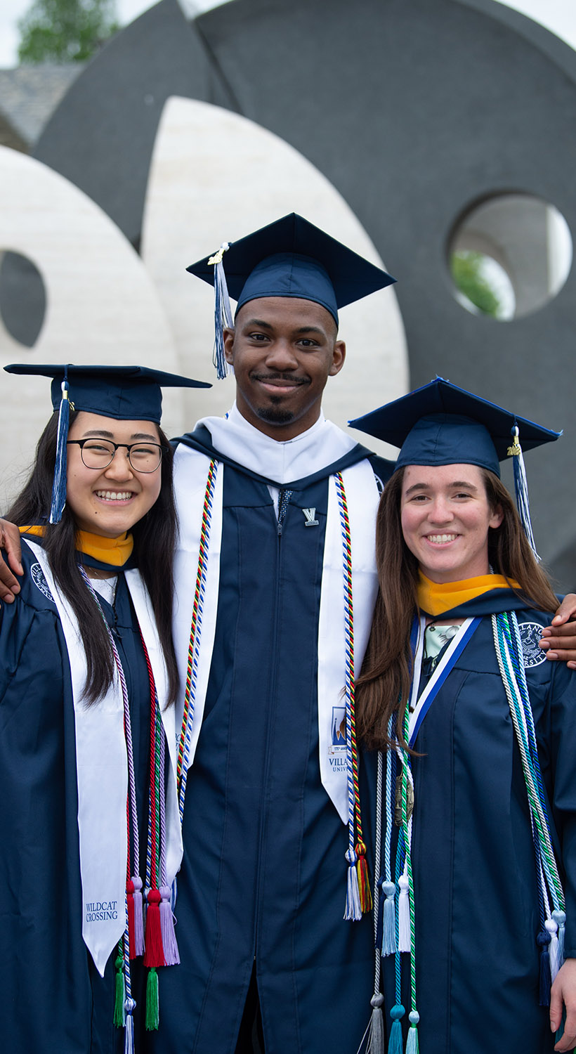 students at graduation in front of the oreo