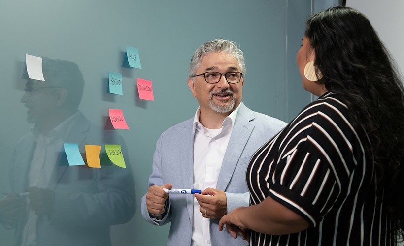 Edward Fierros, PhD, associate dean UNITAS: Inclusive Education, talks with a student.