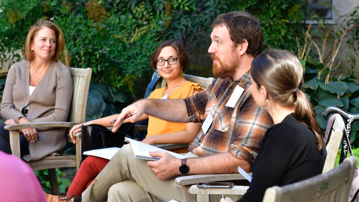 Three alumni speaking with Dr. Anna Moreland in September 2023