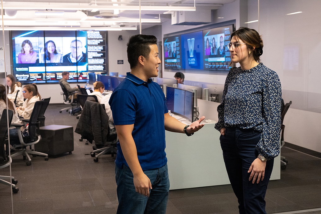 Male and female student talking outside of computer lab