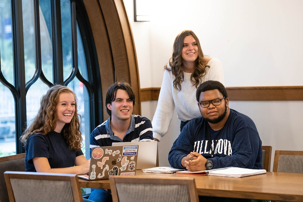 Students gathered around a table smiling