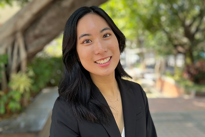 Environmental headshot of Agnes Hwang smiling directly at the camera wearing a black blazer.
